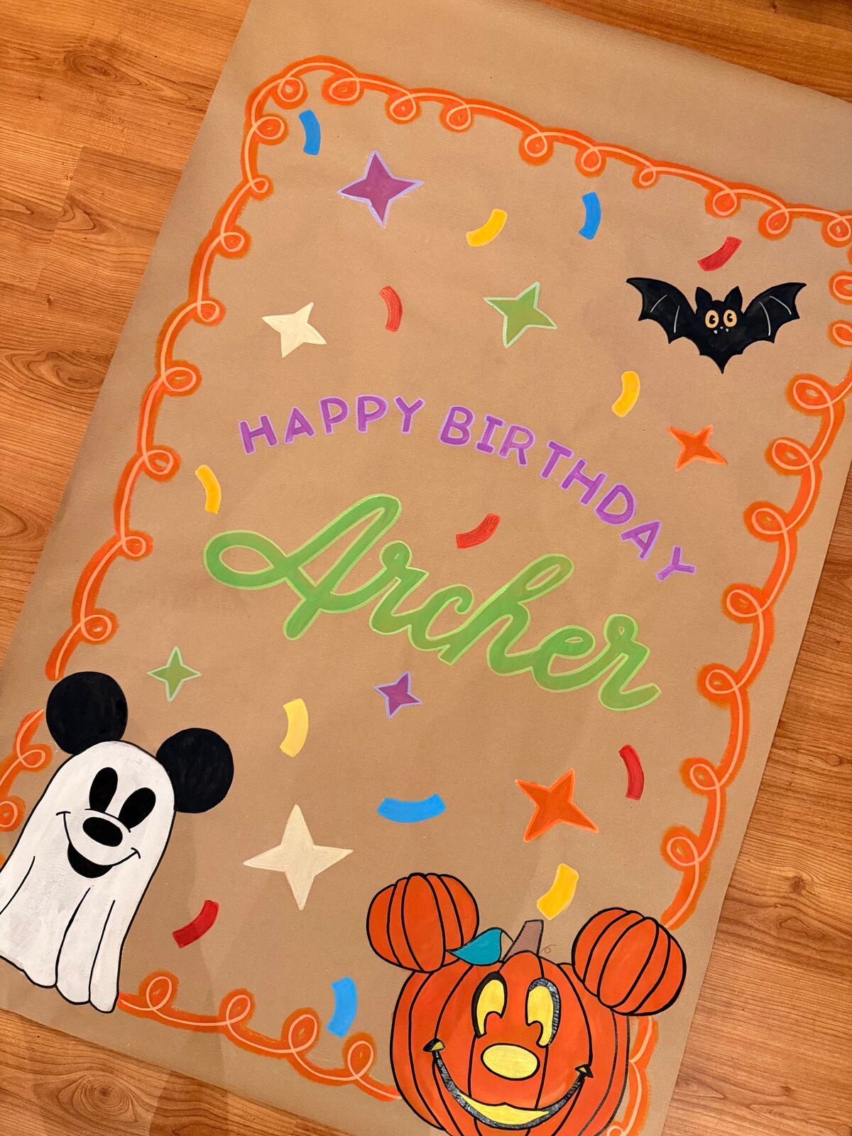 The “Happy Birthday Archer” Halloween banner on a wooden floor, seen from a little further back.